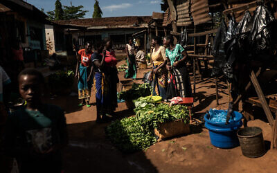 Women sell vegetables in a local market in Kaliyeka in Lilongwe, Malawi on February 22, 2023. (Fredrik Lerneryd/AFP)