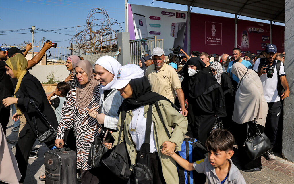 People walk through a gate to enter the Rafah border crossing to Egypt in the southern Gaza Strip on November 1, 2023 (Mohammed ABED / AFP)