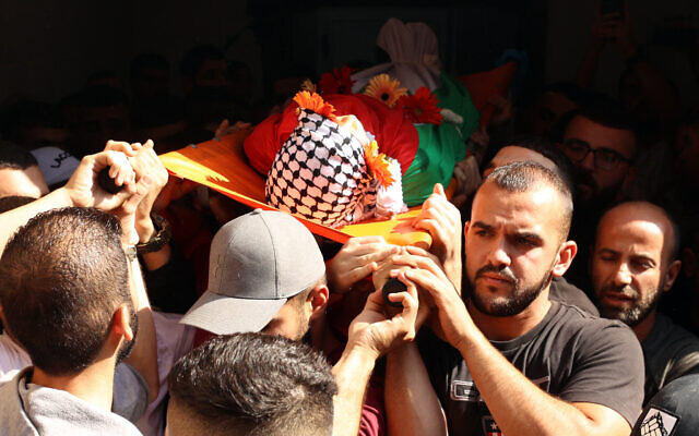 People carry the body of Ayham Shafei, who was killed during an Israeli raid, during his funeral in Ramallah in the West Bank on November 2, 2023. (Photo by Zain JAAFAR / AFP)
