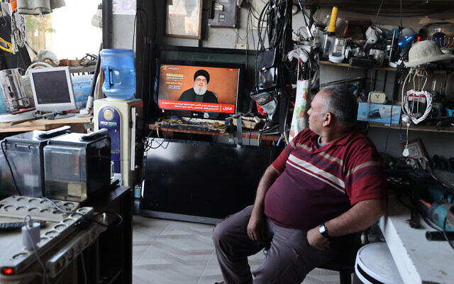 A man sitting in a shop watches the televised speech of Lebanon's Hezbollah chief Hasan Nasrallah, in the West Bank town of Tubas on November 3, 2023 (Jaafar ASHTIYEH / AFP)