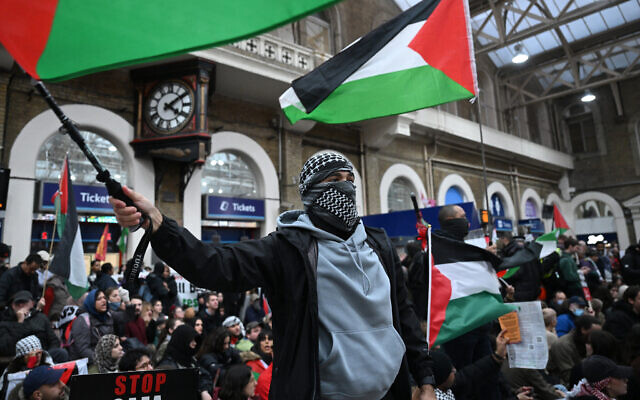 A protester waves a Palestinian flag as people take part in a sit-in protest inside Charing Cross station following the 'London Rally For Palestine' in, central London on November 4, 2023, as they call for a ceasefire in the conflict between Israel and Hamas. (JUSTIN TALLIS / AFP)