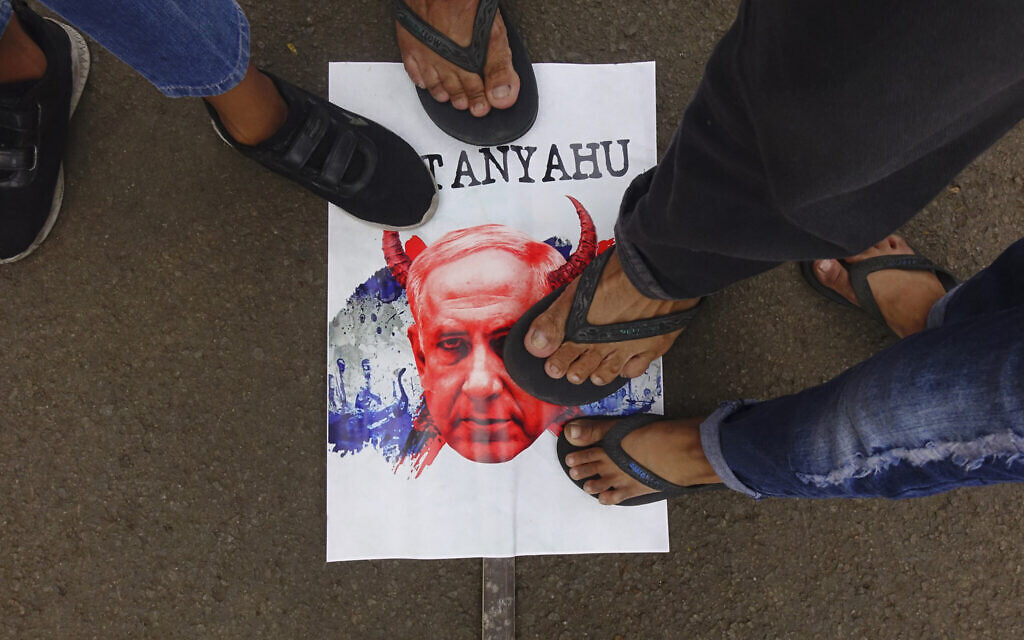 People step on a caricature of Prime Minister Benjamin Netanyahu during a rally to show their solidarity with Palestinians at the National Monument in Jakarta on November 5, 2023. (Photo by Azwar IPANK / AFP)
