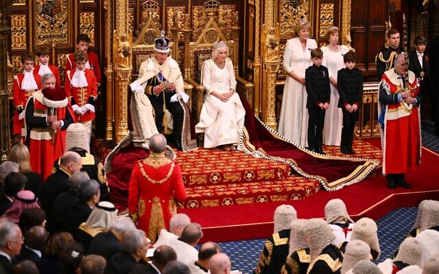 Britain's King Charles III, wearing the Imperial State Crown and the Robe of State, sits beside Britain's Queen Camilla, wearing the George IV State Diadem, as he reads the King's speech from The Sovereign's Throne in the House of Lords chamber, during the State Opening of Parliament, at the Houses of Parliament, in London, on November 7, 2023. (Leon Neal / POOL / AFP)