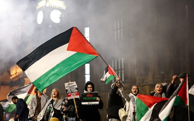 Protesters hold placards and flags and chant slogans at a rally in support of Palestinians and against Israel, outside of the Houses of Parliament in central London on November 15, 2023. (Henry Nicholls/ AFP)