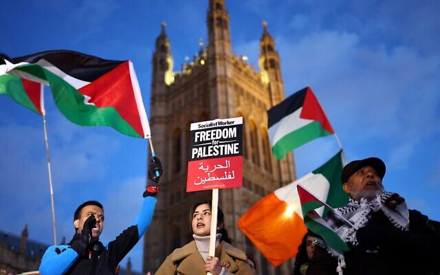 Protesters hold placards and flags as they chant slogans during a rally in support of Palestinians, outside of the Houses of Parliament in central London on November 15, 2023, to demand Members of Parliament vote for a ceasefire in Gaza. (Henry Nicholls / AFP)
