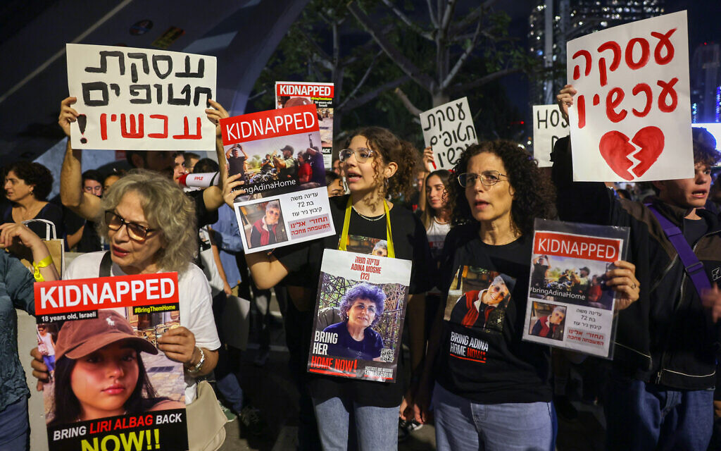 Relatives and supporters of hostages held in Gaza since the Hamas's October 7 attack in southern Israel, hold placards and images of those taken, during a demonstration outside the Defense Ministry in Tel Aviv calling for a deal to be made by the Israeli government for their release, on November 15, 2023. (AHMAD GHARABLI / AFP)