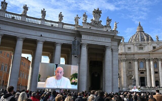 Faithful gather to attend the Angelus prayer on a screen, led by Pope Francis in St. Peter's Square at the Vatican on November 26, 2023. (Alberto PIZZOLI / AFP)