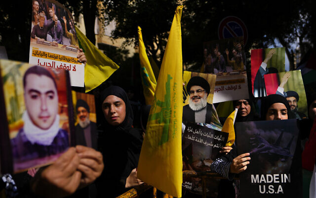 Hezbollah supporters hold flags and portraits of terror leader Sayyed Hassan Nasrallah during a protest in solidarity with the Palestinian people in Gaza, in the southern suburb of Beirut, Lebanon  October 18, 2023. ( AP Photo/ Hassan Ammar)