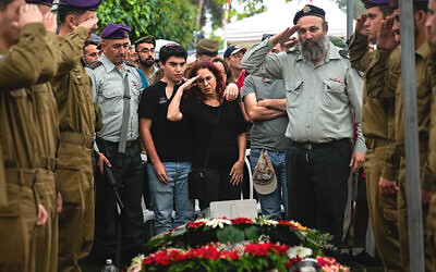Israeli soldiers and Shlomit Lipshitz, center, mother of Staff Sgt. Lavi Lipshitz, salute over the grave of her son during his funeral in the Mount Herzl Military Cemetery in Jerusalem, November 1, 2023. (AP Photo/Ohad Zwigenberg)
