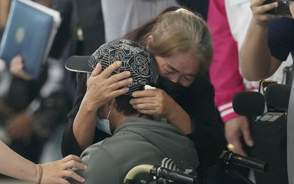 A relative hugs a Thai overseas worker who was evacuated from Israel after Hamas's October 7 attacks, as he and others arrived at Suvarnabhumi International Airport in Samut Prakarn Province, Thailand, on October 12, 2023. (AP Photo/Sakchai Lalit, File)