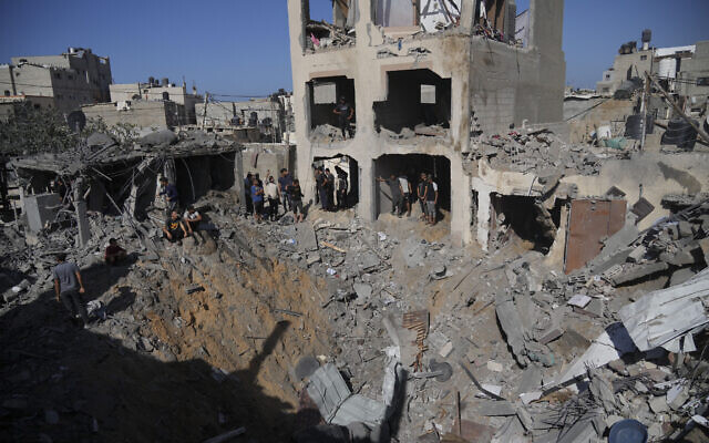 Palestinians look at buildings destroyed in an Israeli strike in Deir al Balah, Gaza Strip, November 7, 2023. (Hatem Moussa/AP)