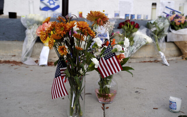 Flowers and flags are left at a makeshift shrine placed at the scene of a confrontation that lead to death of pro-Israel demonstrator Paul Kessler, November 7, 2023, in Thousand Oaks, California. (AP Photo/Richard Vogel)