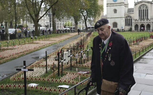 A veteran walks besides the Poppy crosses at the 'Field of Remembrance' at the Westminster Abbey in London, November 8, 2023. (Kin Cheung/AP）