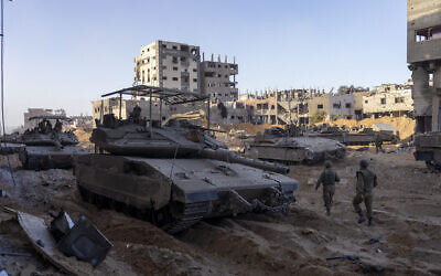 Israeli army troops are seen next to a destroyed building during a ground operation in the Gaza Strip on Wednesday, Nov. 8, 2023., Wednesday, Nov. 8, 2023. (AP Photo/Ohad Zwigenberg)