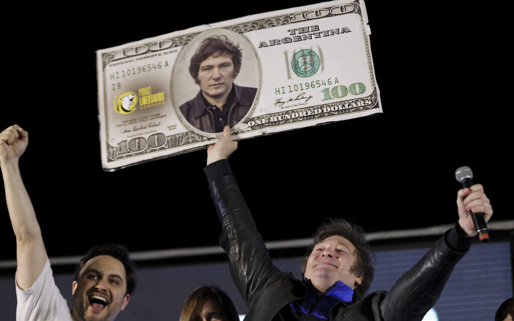 Javier Milei, Liberty Advances coalition presidential candidate, holds a cardboard image of a US 100 dollar bill bedecked with an image of his his face during his closing campaign rally in Cordoba, Argentina, November 16, 2023. (AP Photo/Nicolas Aguilera)