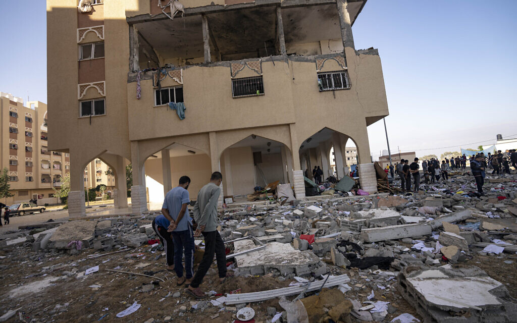 Palestinians look at destruction after a reported Israeli air strike in Khan Younis in the southern Gaza Strip, Nov. 18, 2023. (AP Photo/Fatima Shbair)
