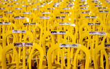 An installation of eyes on empty chairs symbol of the people missing and held captive in Gaza, in Tel Aviv Israel, November 21, 2023. (AP Photo/Ariel Schalit)