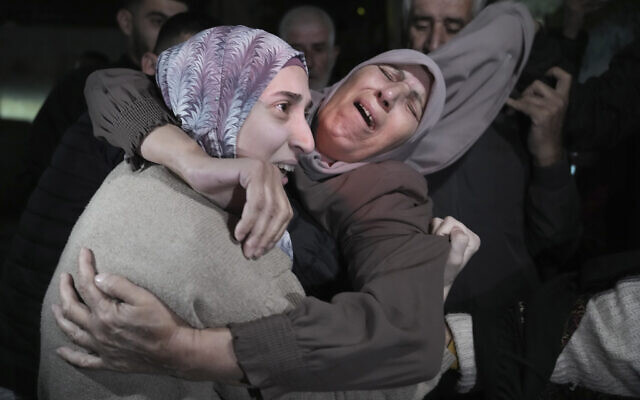 Shuruq Dwayat, left, a Palestinian prisoner released by Israel, is hugged by relatives as she arrives home in the East Jerusalem neighborhood of Sur Bahar, early Sunday Nov. 26, 2023. (AP Photo/Mahmoud Illean)