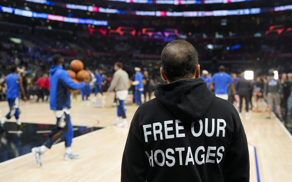 David Vered wears a hoodie with a message that says 'Free Our Hostages' as players warm up for an NBA basketball game between the Los Angeles Clippers and the Dallas Mavericks on Nov. 25, 2023, in Los Angeles. (AP Photo/Jae C. Hong)