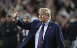 Republican presidential candidate and former US president Donald Trump waves during halftime of an NCAA college football game between South Carolina and Clemson, November 25, 2023, in Columbia, South Carolina. (Artie Walker Jr./AP)