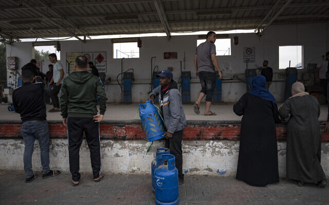 Palestinians line up for cooking gas during the second day of the temporary ceasefire between Hamas and Israel in Khan Younis, Gaza Strip, November 25, 2023. (AP Photo/ Fatima Shbair)