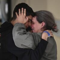This handout photo provided by Haim Zach/GPO shows Sharon Hertzman, right, hugging a relative as they reunite at Sheba Medical Center in Ramat Gan, Israel, Saturday Nov. 25, 2023. Sharon Hertzman and her daughter Noam, 12 years old, not pictured, were released by Hamas after being held as hostages in Gaza for 50 days. (Haim Zach/GPO/Handout via AP)