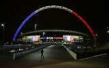 The arch of Wembley Stadium in London is seen lit up in the colors of the French flag above the words translated from French 'Liberty, Equality, Fraternity' as a mark of respect to the victims of the deadly attacks in Paris, November 16, 2015. (Matt Dunham/AP)