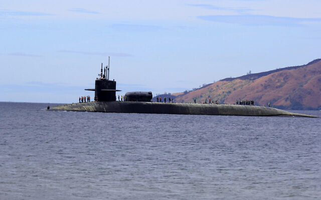 US Navy crew stand on the USS Michigan (SSGN-727), an Ohio-class guided missile submarine, as it prepares to dock at Subic Freeport, a former US naval base Tuesday, March 25, 2014 about 70 kilometers (44 miles) west of Manila, Philippines. (AP/Jun Dumaguing)