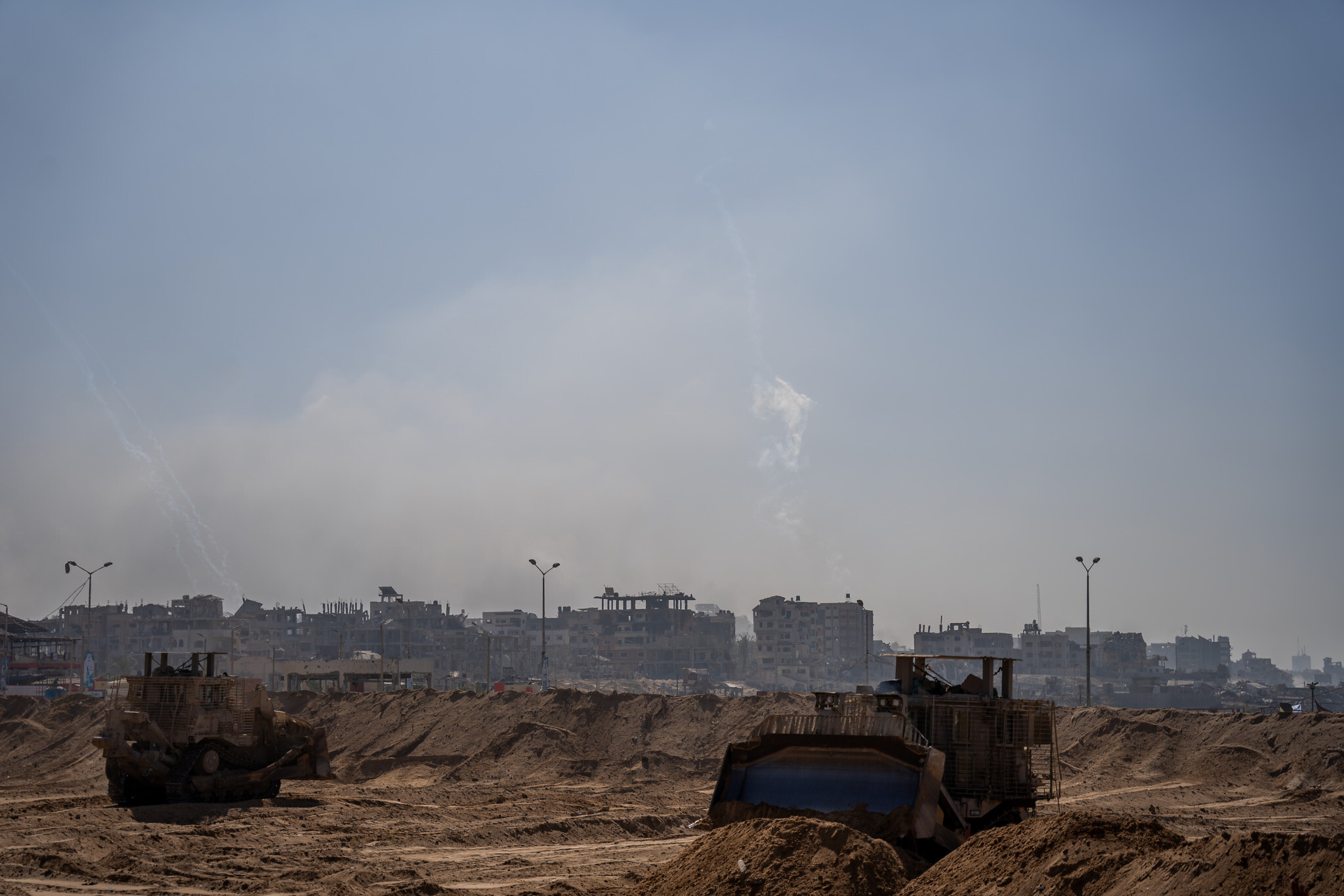 Rockets are fired toward Israel, as Combat Engineering Corps D9 bulldozers flatten land in the northern Gaza Strip, November 7, 2023. (Emanuel Fabian/Times of Israel)