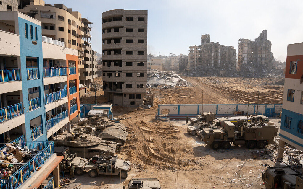 Damaged buildings and Israeli troops are seen in the northern Gaza Strip, November 16, 2023 (Emanuel Fabian/Times of Israel)