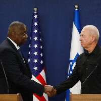 Defense Minister Yoav Gallant, right, and his US counterpart Lloyd Austin shake hands while delivering joint statements at the Kirya military base in Tel Aviv on October 13, 2023. (Miriam Alster/Flash90)