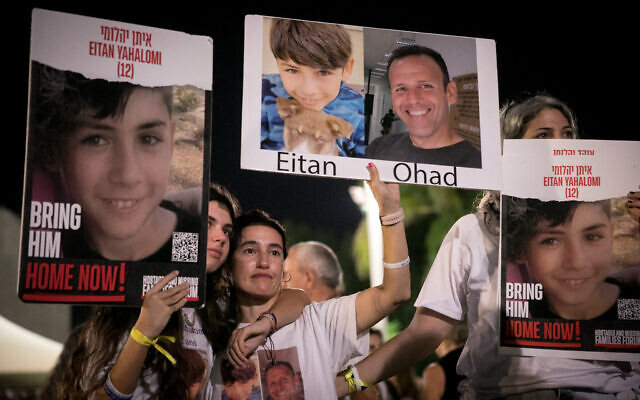 Israelis hold up photographs of people held hostage by terrorists in Gaza in Tel Aviv, November 3, 2023. (Miriam Alster/Flash90r)