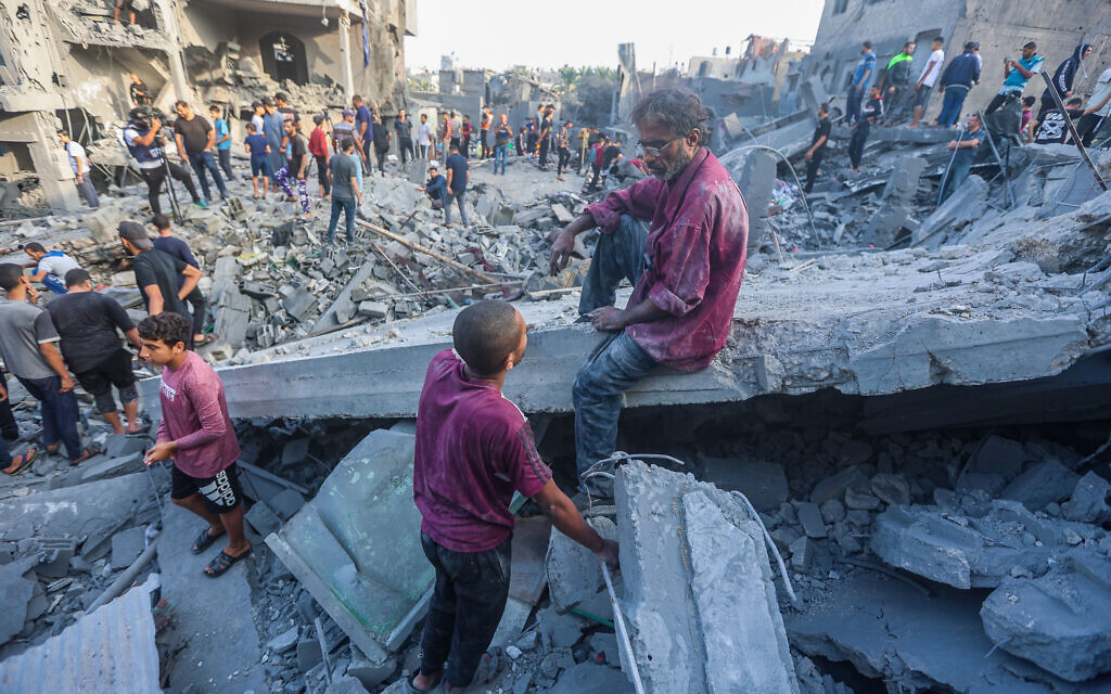 Palestinians at the rubble of a destroyed building after an Israeli airstrike in the central Gaza Strip, on November 5, 2023. (Atia Mohammed/Flash90)