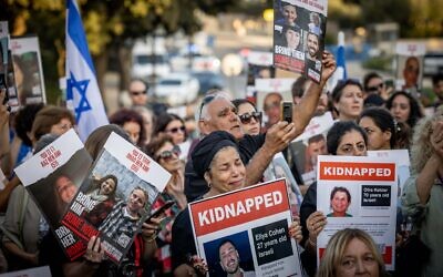 Hundreds of Israelis holding photographs of abducted and missing family members protest outside the Knesset, many demanding that any ceasefire be conditioned on their release, November 6, 2023. (Yonatan Sindeli/Flash90)