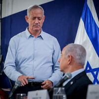 File - War cabinet Minister Benny Gantz (standing), Prime Minister Benjamin Netanyahu (center), and Defense Minister Yoav Gallant, at a press conference at the Defense Ministry headquarters in Tel Aviv, November 22, 2023. (Chaim Goldberg/Flash90)