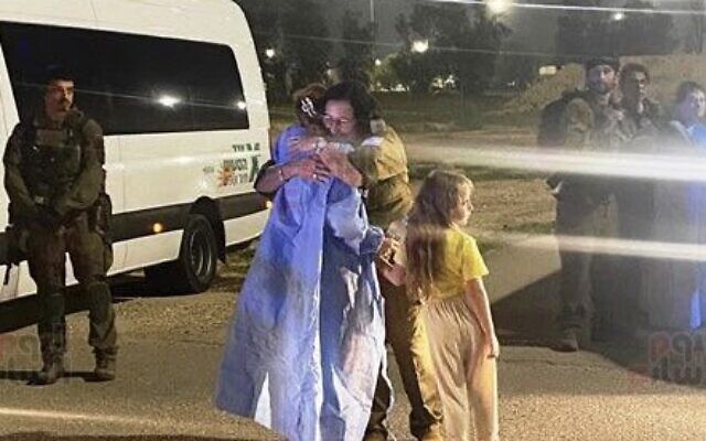 An IDF officer embraces Danielle Aloni after her embrace from Hamas captivity on November 24, 2023. (Courtesy)