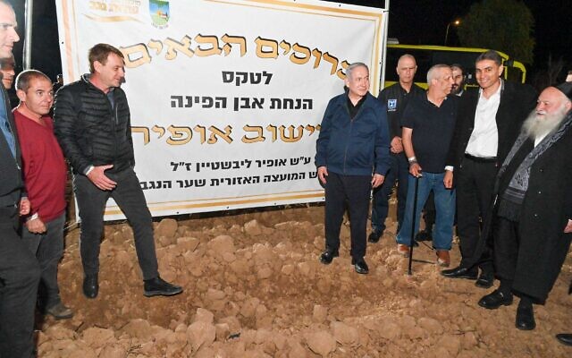 Prime Minister Benjamin Netanyahu, center, lays the foundation stone for a new community, Ofir, as he meets with municipal leaders of communities close to the Gaza Strip, November 29, 2023. (Kobi Gideon/GPO)