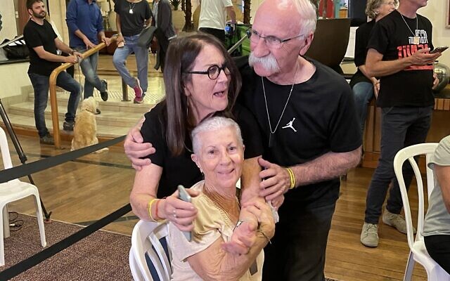 Simcha Shani, grandmother of Amit Shani, hugs her grandson’s other grandparents Musa and Dahlia Weissman after receiving news that Amit has been released from captivity in Gaza, November 30, 2023. (Jeremy Sharon/The Times of Israel)