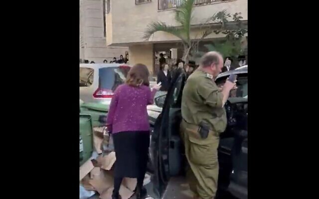 A Haredi reservist soldier (right) is mobbed by ultra-Orthodox extremists in the city of Bnei Brak, November 20, 2023. (Twitter video screenshot: used in accordance with Clause 27a of the Copyright Law)