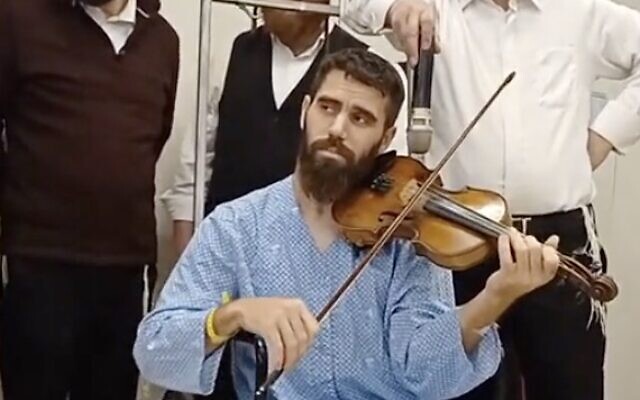 Mordechay Shenvald plays violin at the Barzilai Medical Center on November 20, 2023. (Screen capture/X)