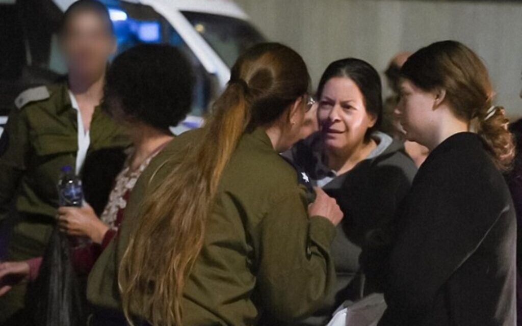 Noga Weiss, 18, right, and her mother Shiri Weiss, 53, second from right, are received by IDF soldiers after being freed from captivity in Gaza, November 25, 2023. (Israel Defense Forces)