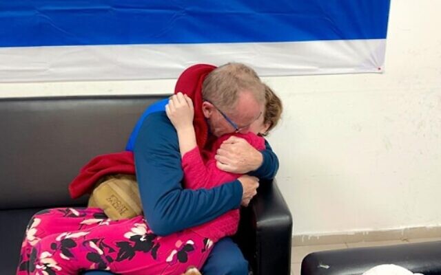 Tom Hand embraces his daughter Emily Hand as they reunite, in the early hours of November 26, 2023. (Israel Defense Forces)