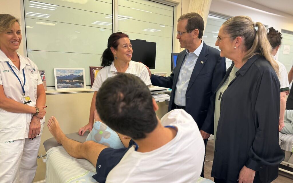 President Isaac Herzog and his wife Michal Herzog (right) visit with a wounded soldier and staff at the Loewenstein Rehabilitation Hospital in Ra'anana, November 13, 2023 (Courtesy of Loewenstein Hospital)