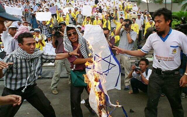 Illustrative: Indonesian Islamic students burn an Israeli flag during a protest at the national parliament in Jakarta on November 11, 1999, against plans by the new government to open trade ties with the Jewish state. (Photo by KENZO TRIBOUILLARD / AFP)