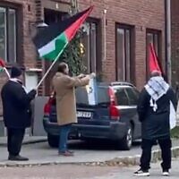 A demonstrator burns an Israeli flag outside a synagogue in Malmo, Sweden, on November 4, 2023. (The Council of Swedish Jewish communities)