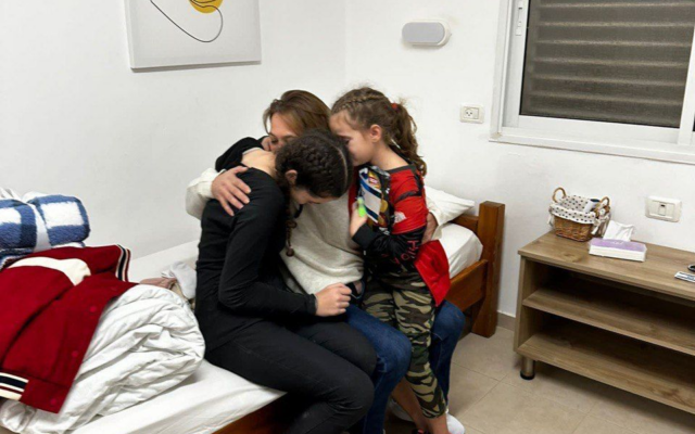 Maayan Zin embraces her daughters, Dafna Elyakim, 15, and Ela Elyakim, 8, after they were released from Gaza captivity on November 26, 2023. (Courtesy)
