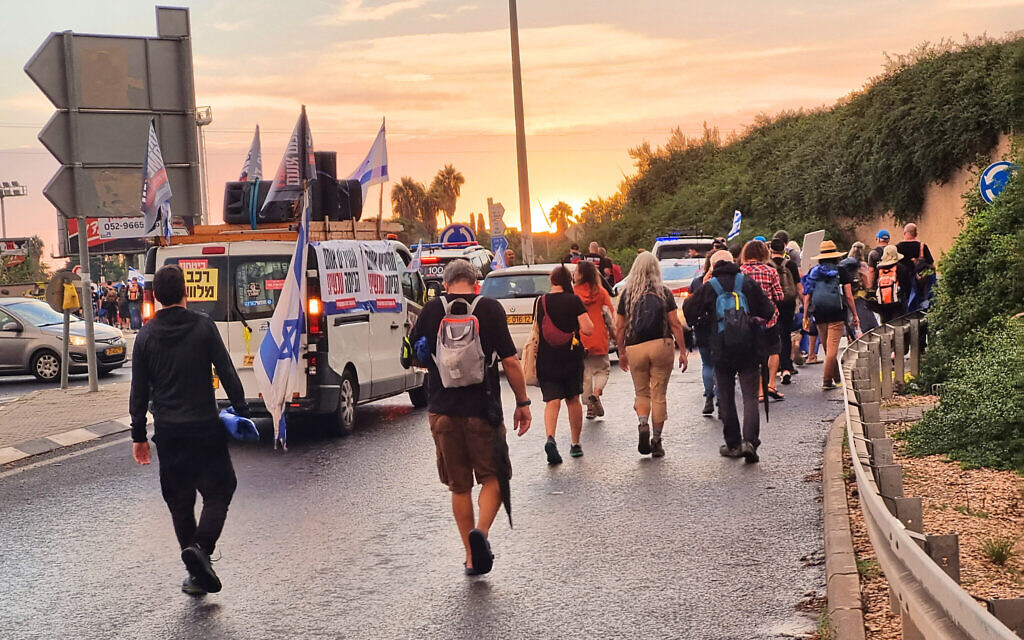 Hostage families march on the road to Be’er Yaakov, November 14, 2023. (Bernard Dichek/Times of Israel)