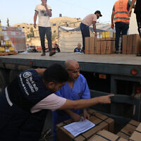 Illustrative: Workers unload medical aid from the World Health Organization at the Nasser hospital in Khan Younis in the southern Gaza Strip on October 23, 2023. (Mahmud Hams/AFP)