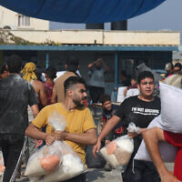 Palestinians storm a UN-run aid supply center that distributes food to displaced families in the Gaza Strip, Deir al-Balah on October 28, 2023. (Mohammed Abed / AFP)