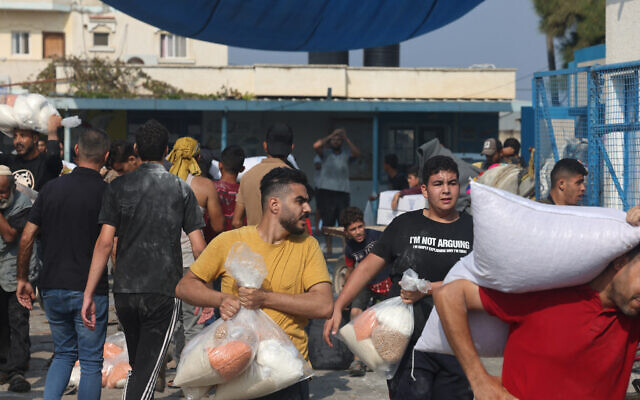 Palestinians storm a UN-run aid supply center that distributes food to displaced families in the Gaza Strip, Deir al-Balah on October 28, 2023. (Mohammed Abed / AFP)